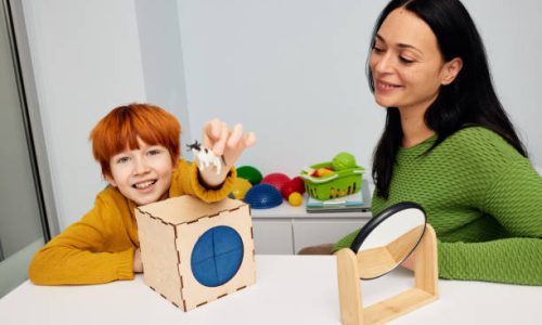 Mental health for kids. Professional kids psychologist working with cute male child in office during play therapy session